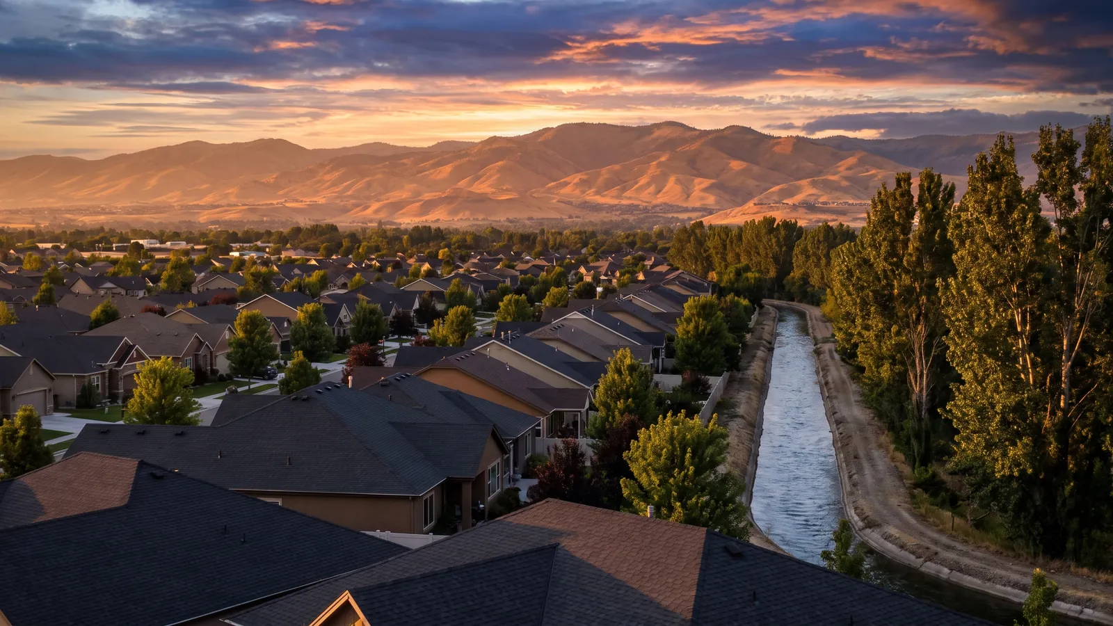 Rooftops of a Meridian, Idaho neighborhood at sunset with the Boise foothills on the horizon